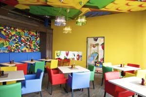 a dining room with tables and colorful chairs at aja Grömitz in Grömitz