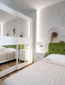 een witte slaapkamer met een spiegel en een bed bij MILLE SUITE GARDEN in Noto +79 foto's