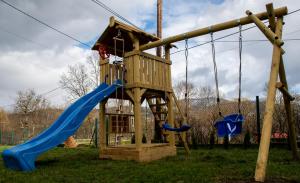 a wooden playground with a blue slide and a slideintend at Dom Wypoczynkowy - Alexander in Cisiec