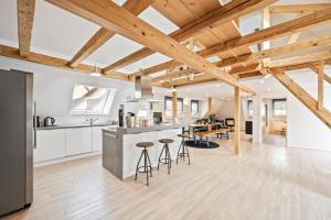 uma cozinha em plano aberto e sala de estar com tectos em madeira em Sali Homes- Penthouse em Obersulm