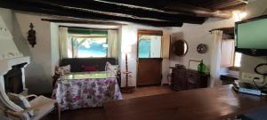 a living room with a table and a tv at La Casería in Navaconcejo