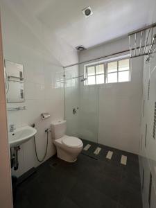 uma casa de banho branca com um WC e um lavatório em D Eastern Hotel em Ipoh