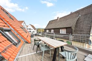a balcony with a wooden table and chairs on it at Sali Homes- Penthouse in Obersulm