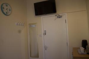 una habitación con dos puertas y un reloj en la pared en Elm Tree Guest House, en Weston-super-Mare