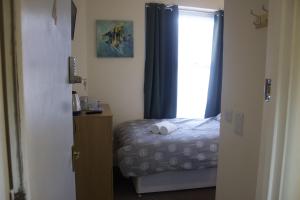 ein kleines Schlafzimmer mit einem Bett und einem Fenster in der Unterkunft Elm Tree Guest House in Weston-super-Mare