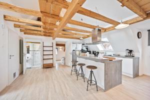 a kitchen with wooden ceilings and a counter with stools at Sali Homes- Penthouse in Obersulm