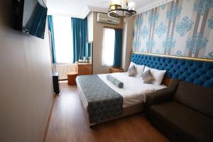 イスタンブールにあるİSTA Golden Palace Hotelのベッドとソファ付きのホテルルーム