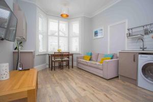 a living room with a couch and a table at Lovely Annexe by the Beach, in Central Worthing. in Broadwater