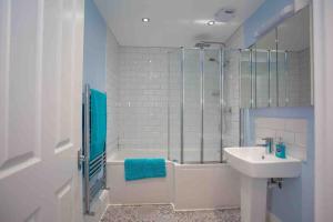 a bathroom with a tub and a sink and a shower at Lovely Annexe by the Beach, in Central Worthing. in Broadwater