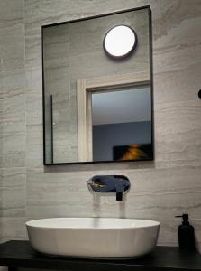 a bathroom with a white sink and a mirror at Solemar Luxury Rooms in Zadar
