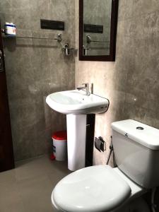 a bathroom with a white toilet and a sink at Anuradhapura Kingdom View Resort in Anuradhapura