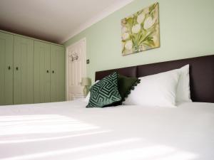 a bedroom with a white bed and green cabinets at Dreamcatcher in South Hayling