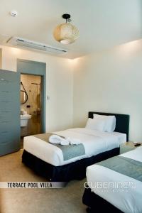 a hotel room with two beds and a bathroom at Cube9 Resort & Spa 큐브9 리조트 & 스파 in Agus