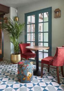 uma mesa e cadeiras num quarto com uma mesa e cadeiras em The New Inn Heckfield em Hook