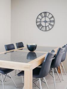a conference room with a table and chairs and a clock at Appartement Meyer-Ernzen in Echternach
