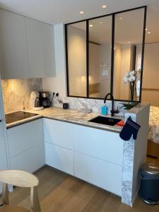 a kitchen with white cabinets and a sink at Studio KZ modern studio in Knokke-Heist