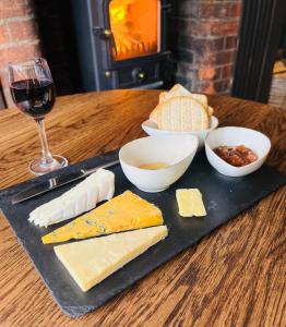 a plate of cheese and a glass of wine on a table at The New Inn Heckfield in Hook