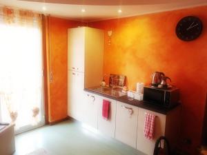 a kitchen with a counter and a clock on the wall at B&B Il Giardino Delle Fate in Lecco +21 photos