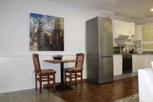 eine Küche mit einem Tisch und Stühlen sowie einem Kühlschrank in der Unterkunft Apartamento Boutique Cruce de Melenara in Melenara