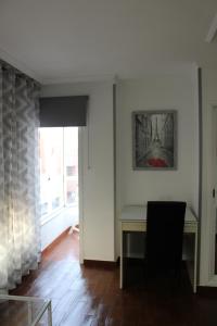 Dieses weiße Zimmer verfügt über einen Schreibtisch und ein Fenster. in der Unterkunft Apartamento Boutique Cruce de Melenara in Melenara