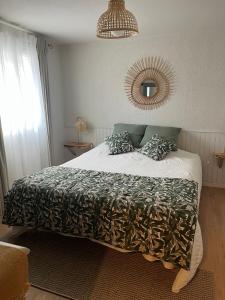 um quarto com uma cama e um espelho na parede em Chambres d'hôtes Marylou em Valensole