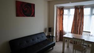 a living room with a black couch and a table at Alphalink house in Middlesbrough