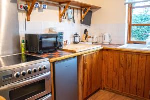 a kitchen with a stove and a microwave at 3-Bed Lodge with direct access to the Tarka trail in Great Torrington