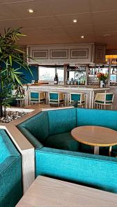 a restaurant with a blue couch and a table at Hotel de l'Europe in Dieppe