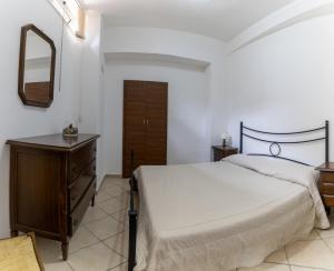 1 dormitorio con cama, tocador y espejo en casa al mare Ippolito, en Santa Maria di Castellabate