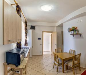 cocina y comedor con mesa y microondas en casa al mare Ippolito, en Santa Maria di Castellabate