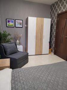 um quarto com uma cama, uma cadeira e uma porta em Studio M em Plovdiv