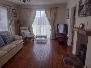 a living room with a couch and a television at Swilly Cottage, Portstewart in Portstewart