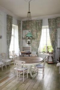 una sala da pranzo con tavolo e sedie di Château de Grandval - Sainte Mere Eglise a Neuville-au-Plain Altre 21 foto