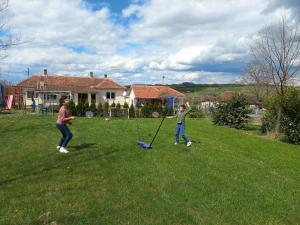 dos niños jugando con un trapeador en un patio en Kuća u selu sa bilijar salom za aktivan odmor, en Mionica