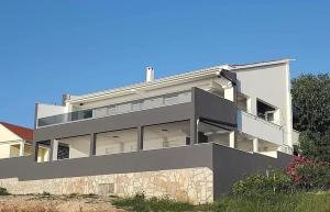 a large white building with a balcony on it at Apartman Mate in Novigrad Dalmatia