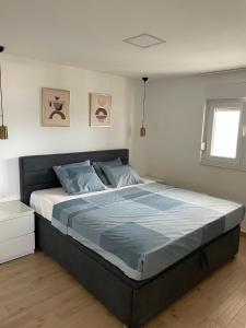 a bedroom with a large bed with blue sheets at Apartman Mate in Novigrad Dalmatia