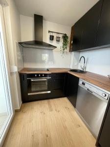 a kitchen with black cabinets and a wooden floor at Apartman Mate in Novigrad Dalmatia +28 photos