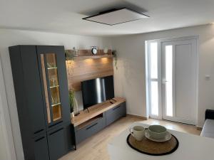 a living room with a tv and a table at Apartman Mate in Novigrad Dalmatia