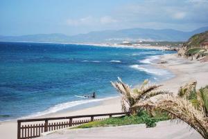 a beach with a person on a surfboard in the water at Little sea town apartment in La Ciaccia