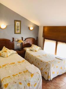 a hotel room with two beds and a window at HOSTAL JJ salduero in Salduero