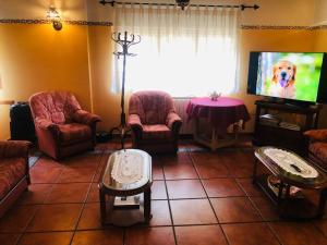 a living room with chairs and a tv and a table at HOSTAL JJ salduero in Salduero