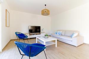 sala de estar con sofá y sillas azules en Villa entre Rose et Pins à Bormes-les-mimosas 4 étoiles - ROSES&PINS, en Bormes-les-Mimosas