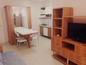 a living room with a table and a tv and a kitchen at Apartamento Serra Park in Rio Quente