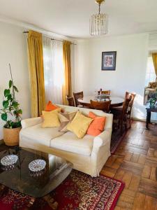 uma sala de estar com um sofá branco e uma mesa em Guest House GAAM Las Condes em Santiago