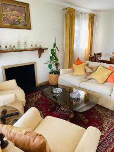 a living room with white furniture and a fireplace at Guest House GAAM Las Condes in Santiago