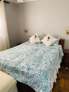 a bedroom with a bed with a blue and white comforter at Guest House GAAM Las Condes in Santiago