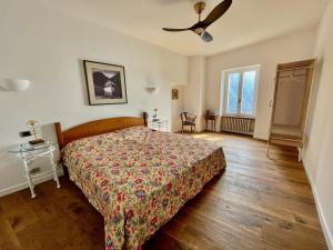 - une chambre avec un lit et un ventilateur de plafond dans l'établissement Historic villa with magnificent lake views, à Valsolda