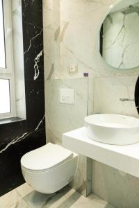 a bathroom with a white toilet and a sink at Tranquil Studio in Tirana in Tirana