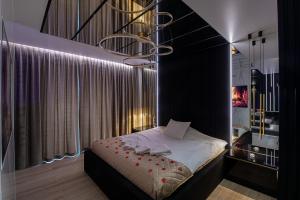 a bedroom with a bed with a chandelier above it at Wiślane Tarasy VIP Apartamenty JACUZZI in Krakow