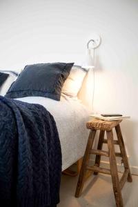 エスビャウにあるHjerting Badehotelのベッド(青い毛布、ランプ付きスツール付)